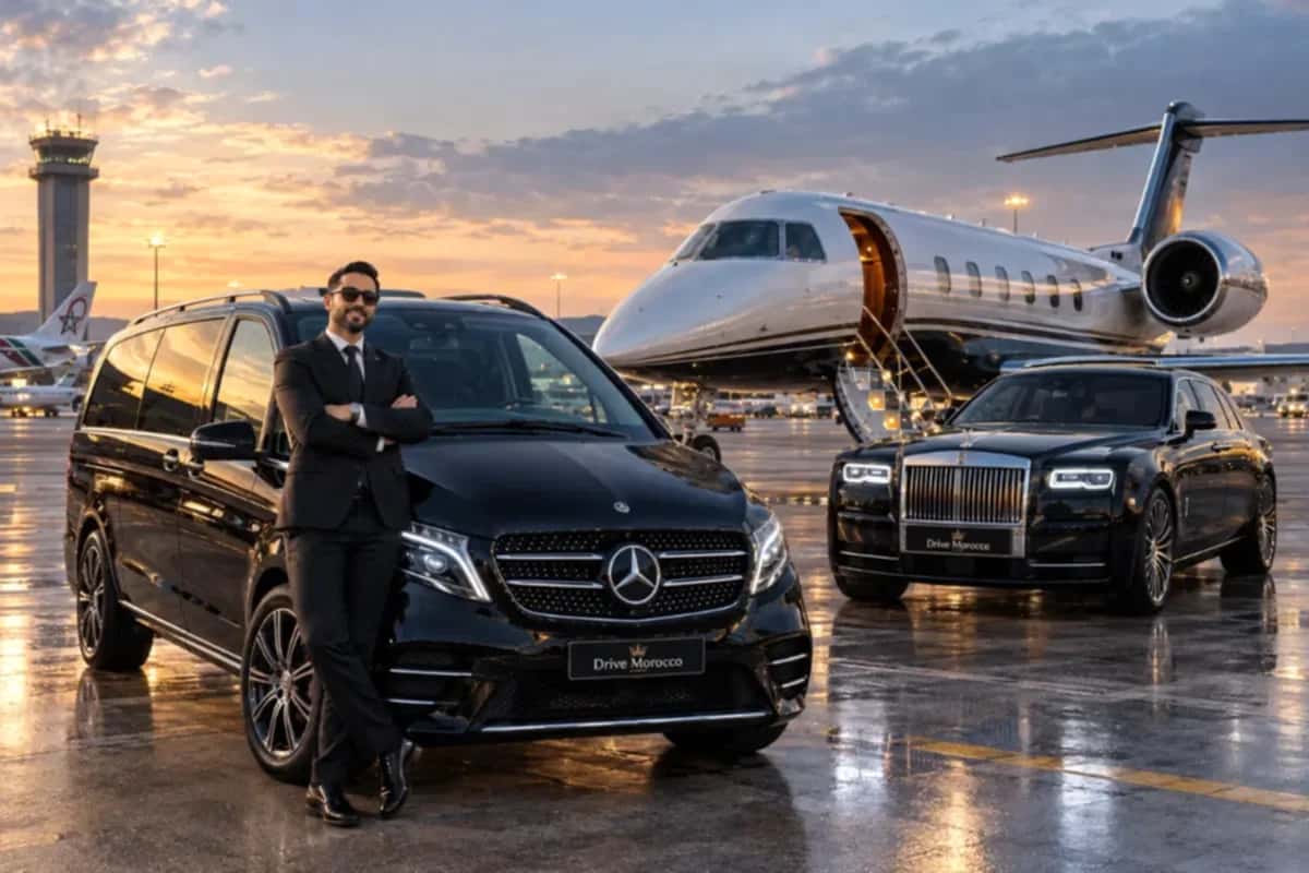 Chauffeur beside a black Mercedes V-Class next to a private jet at sunset