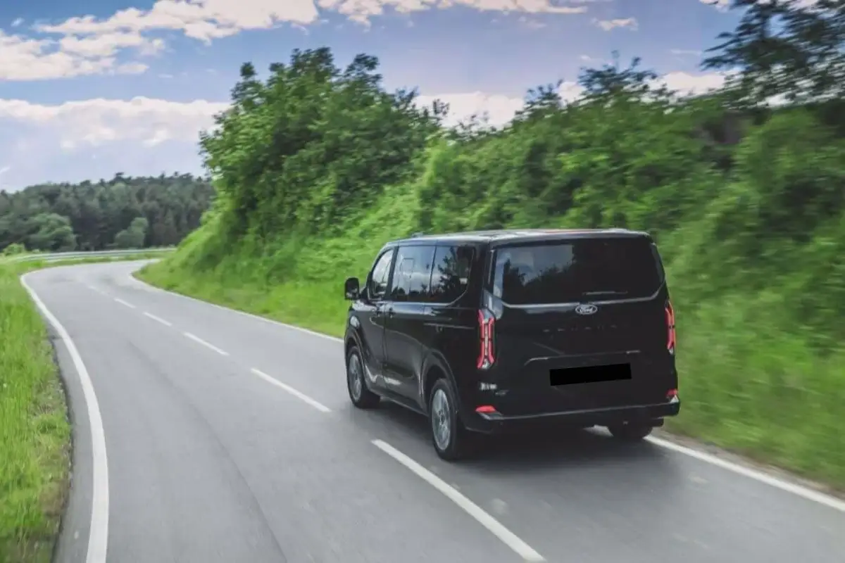 Black private van on an open road during a long-distance transfer